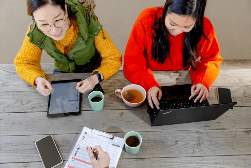 Zwei Frauen arbeiten an Laptop & Tablet